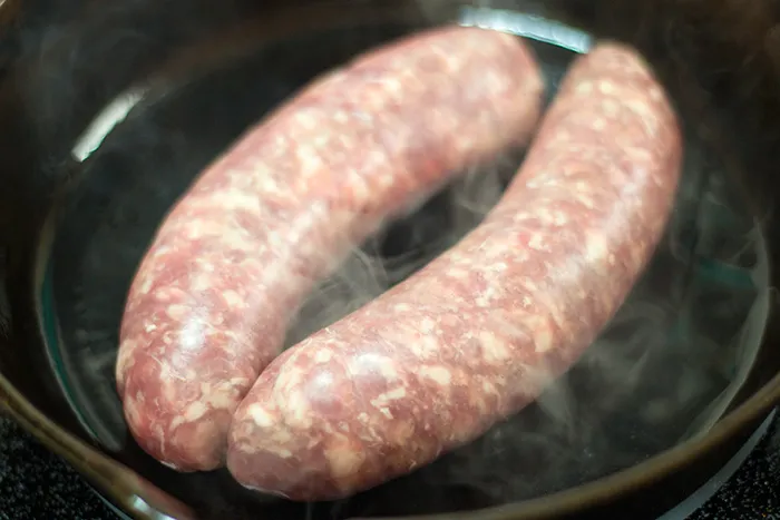 Bratwürste für Currywurst in der Pfanne braten