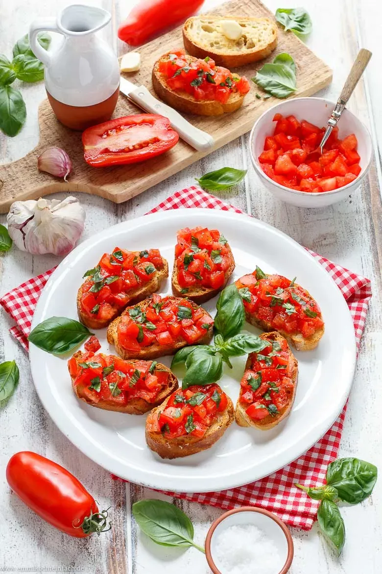 Bruschetta mit Tomaten, Basilikum und Olivenöl, angerichtet auf einem Teller.