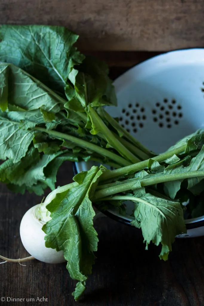 Bündel grüner Spargel und ganze Mairübchen als frische Frühlingszutaten für ein leichtes Gericht