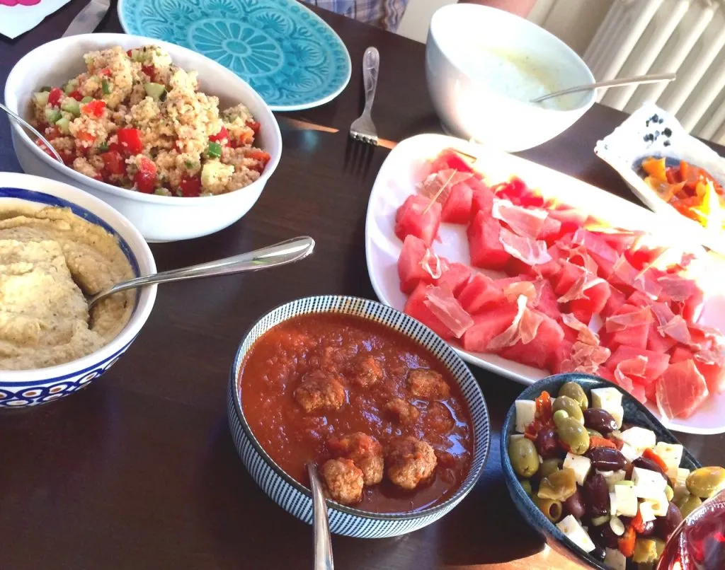 Bunte Auswahl an Tapas-Gerichten auf einem Tisch, darunter Albondigas, ideal für eine entspannte Sommerparty.