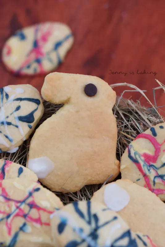 Bunte Osterplätzchen mit Schmandteig, dekoriert mit farbigem Zuckerguss und kleinen Details.