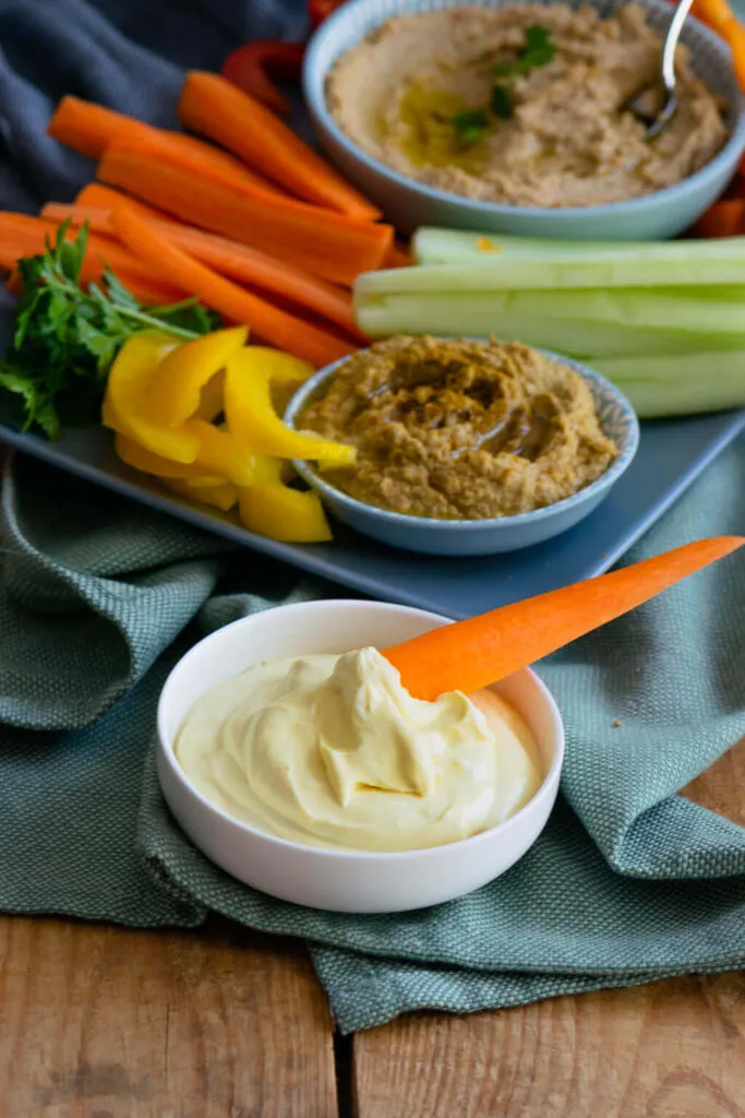 Bunte Rohkostplatte mit verschiedenen Dips wie Hummus und Honig-Senf-Frischkäse