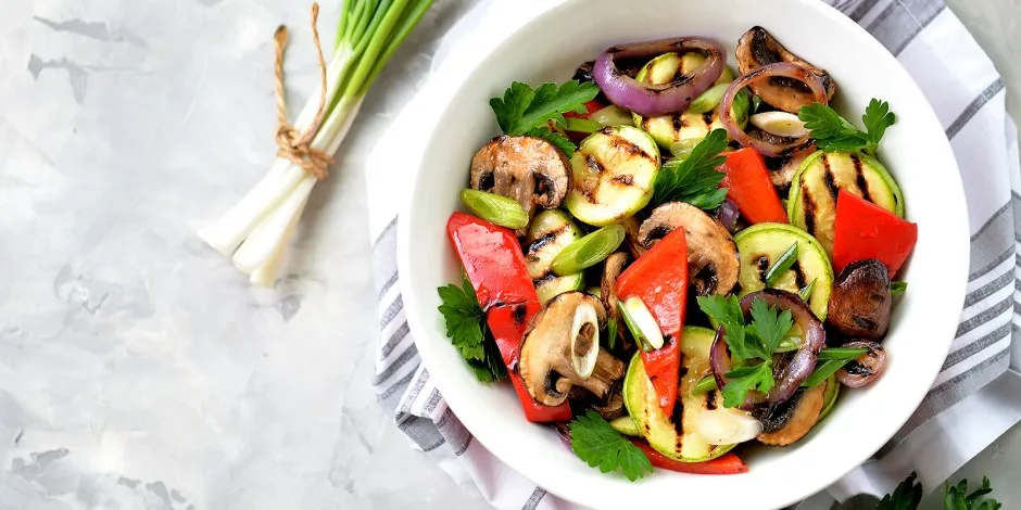 Buntes Arrangement aus frischem Obst, Gemüse und Kräutern, symbolisch für gesunde, cholesterinarme Ernährung.