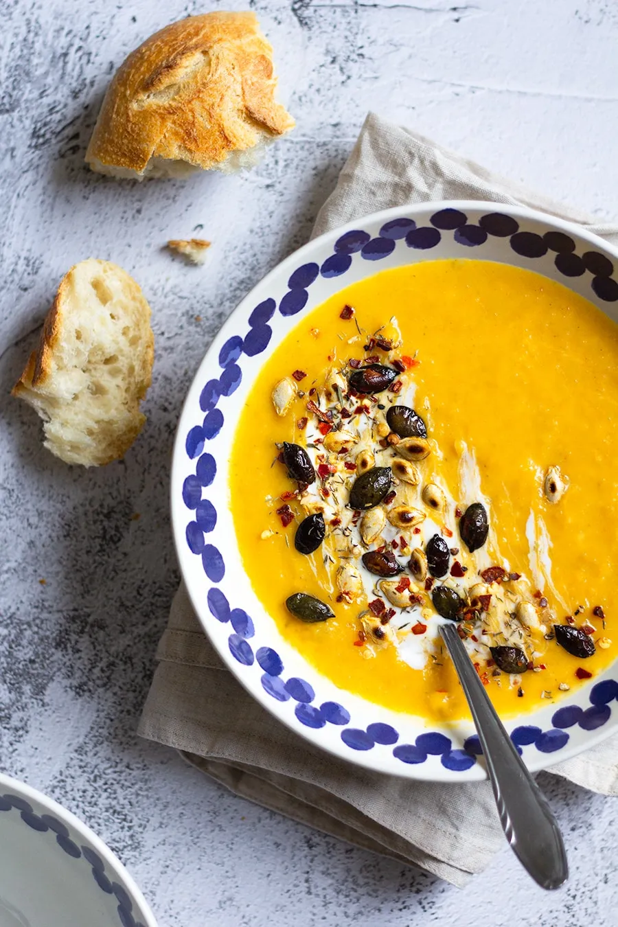 Butternut Kürbis Suppe mit Sellerie und Kräutern in einer rustikalen Schale