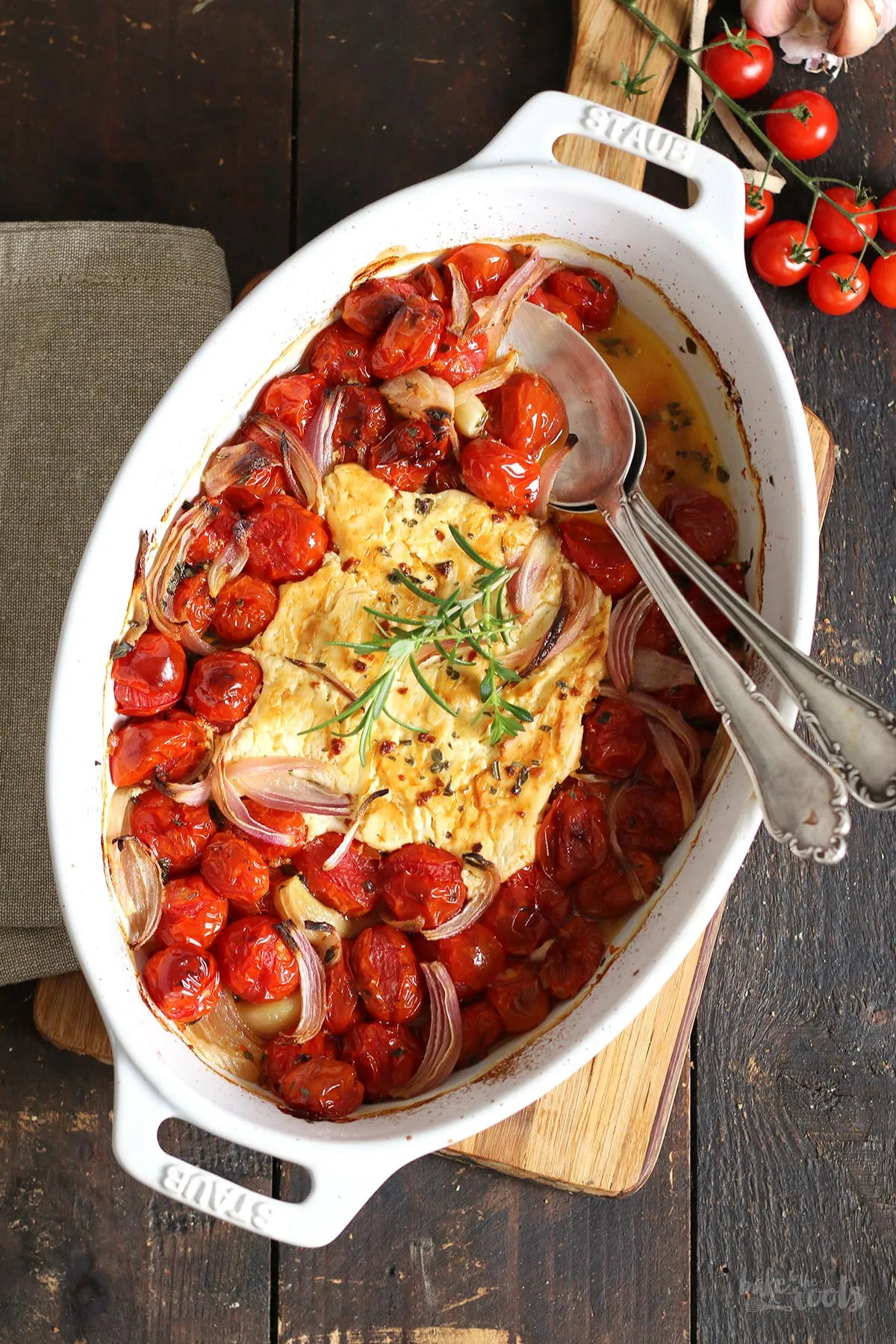 Cherrytomaten, Zwiebel, Knoblauch und Feta in einer Auflaufform bereit zum Backen