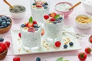 Chia Pudding wird mit frischen Beeren, Obst oder Fruchtpüree serviert