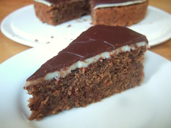 Close-up einer reichhaltigen Marzipantorte mit Schokolade und Haselnüssen, perfekt für die deutsche Kaffeetafel.