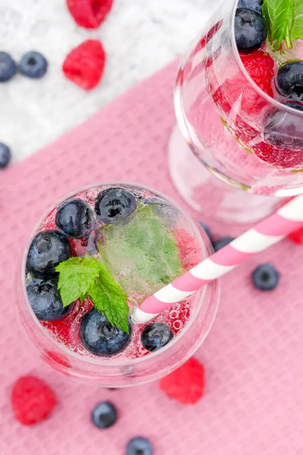 Cocktail mit Heidelbeeren, Minze und Wild Berry mit Strohhalm im Glas