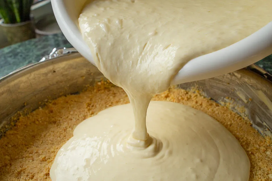 Cremige Kuchenfüllung wird in die vorbereitete Form gegossen