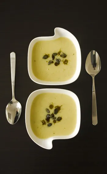 Cremige Kürbissuppe mit Topinambur in einer Suppenschale, garniert