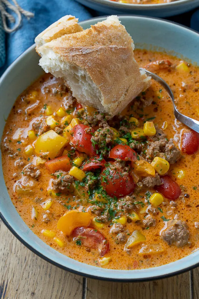 Cremige Pizzasuppe mit frischen Kräutern und geschmolzenem Käse, ideal als schnelle Mahlzeit für die Familie.