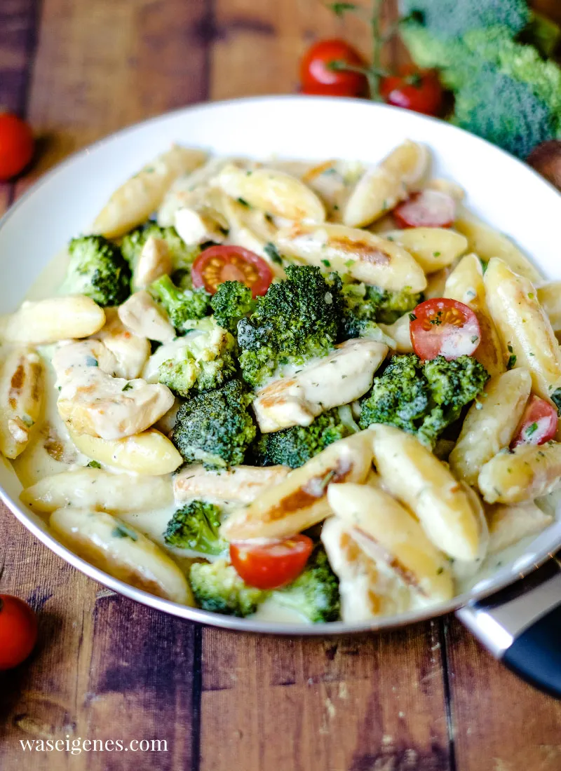 Cremige Sauce aus Wasser, Gemüsebrühe und Frischkäse wird zu den angebratenen Schupfnudeln und Brokkoli gegossen