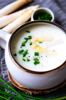 Cremige Spargelsuppe, verfeinert mit weißem Spargelstücken und frischem Schnittlauch, ein beliebtes Spargel Rezept.