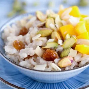 Cremiger Indischer Milchreis (Kheer) mit Mango und Nüssen, laktose- und zuckerfrei.