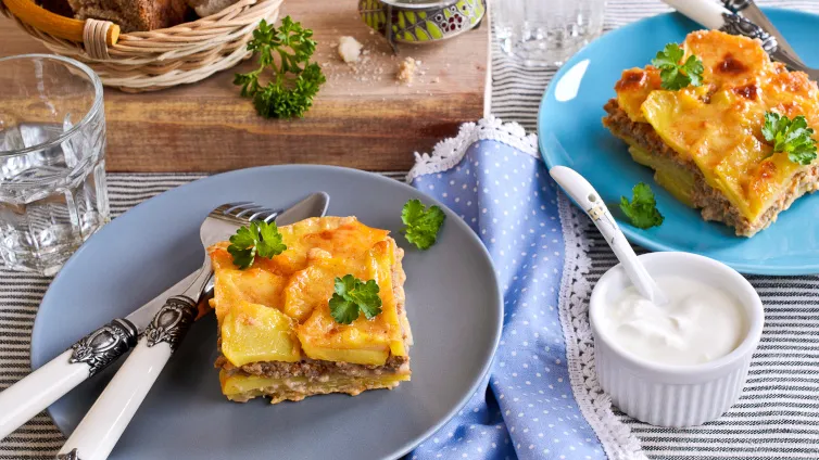 Cremiger Kartoffel-Hack-Auflauf mit goldbrauner Käsekruste, garniert mit frischer Petersilie