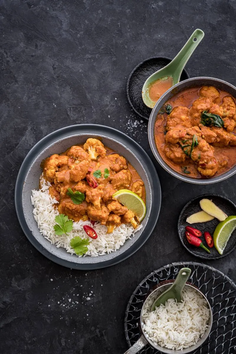 Cremiges Blumenkohl-Curry mit frischem Spinat in einer tiefen Schüssel, ein schnelles und gesundes vegetarisches Asia-Rezept