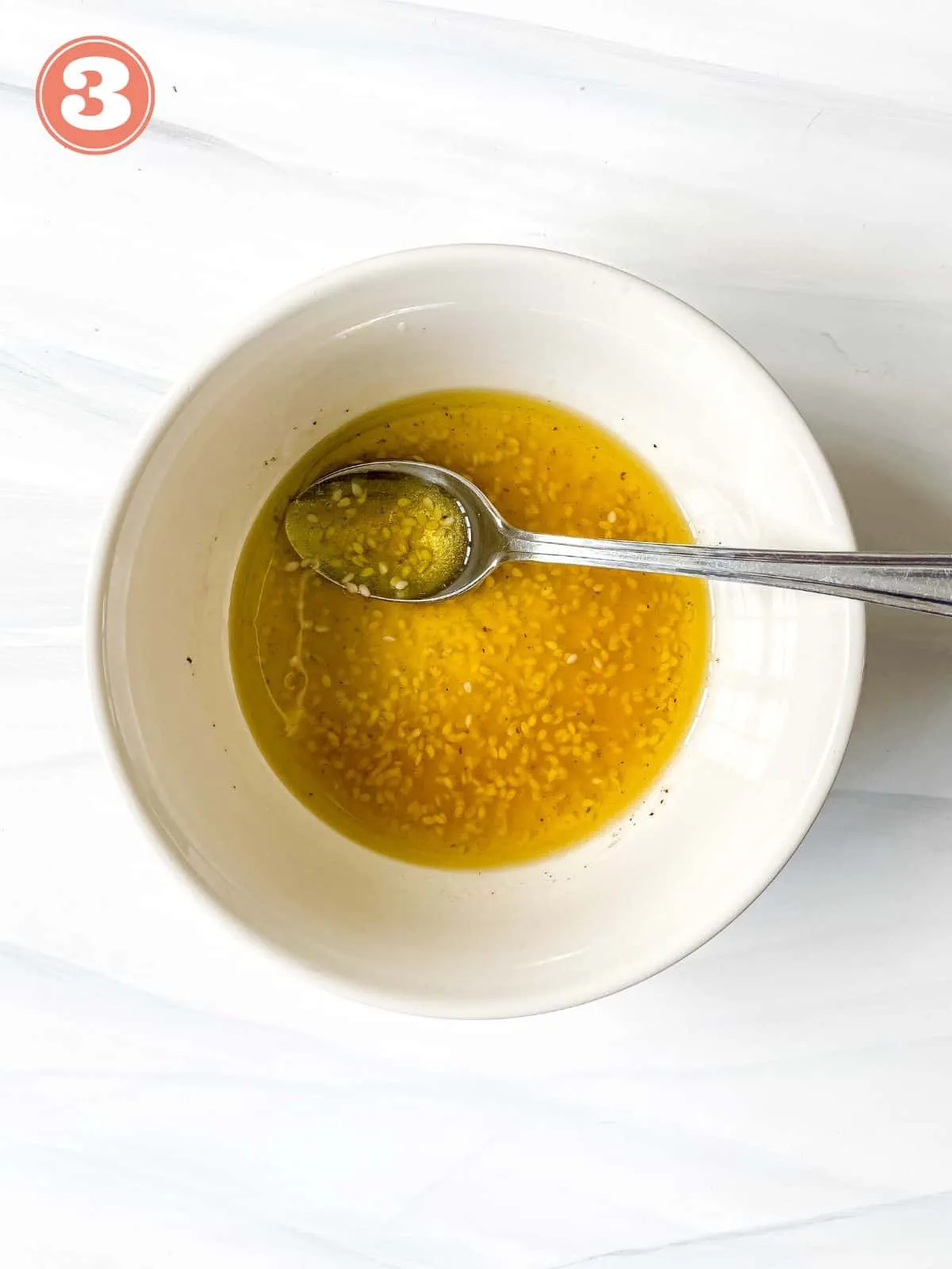 Cremiges Sesam-Dressing in einer weißen Schale mit Löffel, angerührt für den Pak Choi Salat.