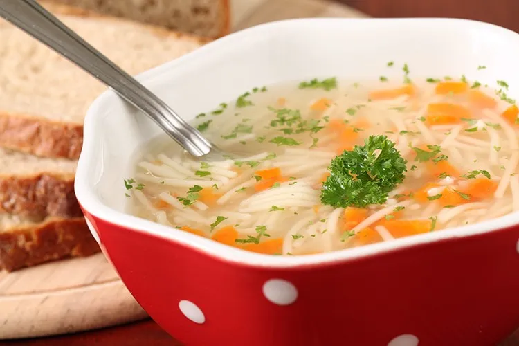 Dampfende Schonkost Nudelsuppe mit zarten Gemüsestücken, ein leichtes und bekömmliches Hauptgericht