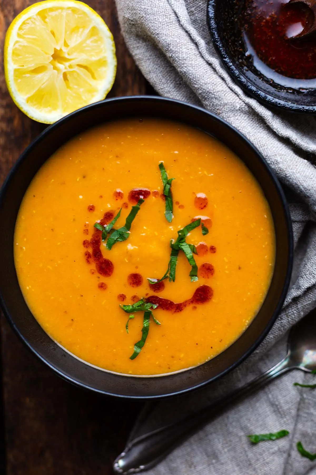 Dampfende türkische Linsensuppe (Mercimek Çorbası) in einer rustikalen Schüssel, garniert mit frischer Petersilie und Paprikabutter