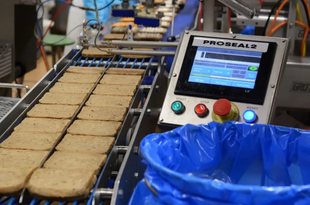 Das Bild zeigt eine Produktionslinie von Brotscheiben, die von LebensmitteltechnikerInnen analysiert werden.