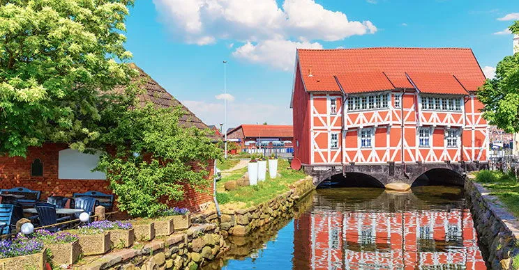 Das Gewölbe: Ein rotes Fachwerkhaus über dem Mühlenbach am alten Wismarer Hafen – ein historischer Ostsee Ferienort.
