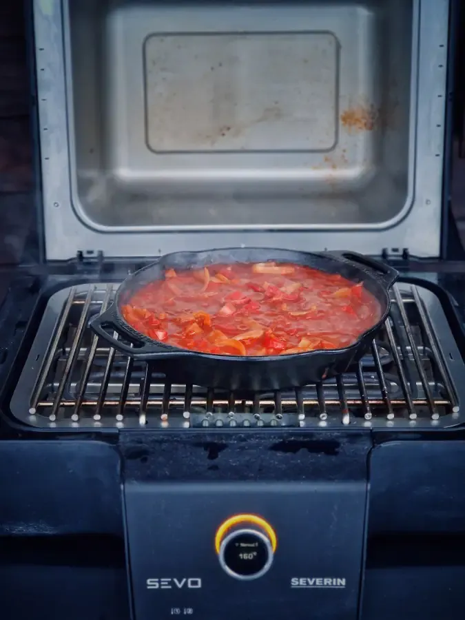 Das ungarische Letscho Rezept köchelt in einer gusseisernen Pfanne auf dem SEVO Elektrogrill und entwickelt sein volles Aroma.
