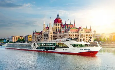 Das ungarische Parlament in Budapest bei Sonnenaufgang, vom Flusskreuzfahrtschiff nickoVISION aus betrachtet.