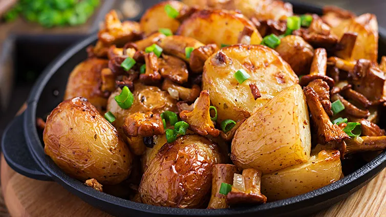 Deftige Kartoffel-Pfifferling-Pfanne mit frischen Frühlingszwiebeln, perfekt für den Herbst