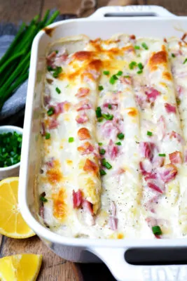 Deftiger Spargelauflauf mit Kartoffeln und Schinken in einer Auflaufform, ideal als Familiengericht.