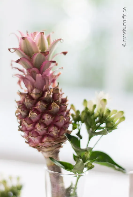 Dekorative Mini-Ananas und Servietten als festliche Tischdekoration