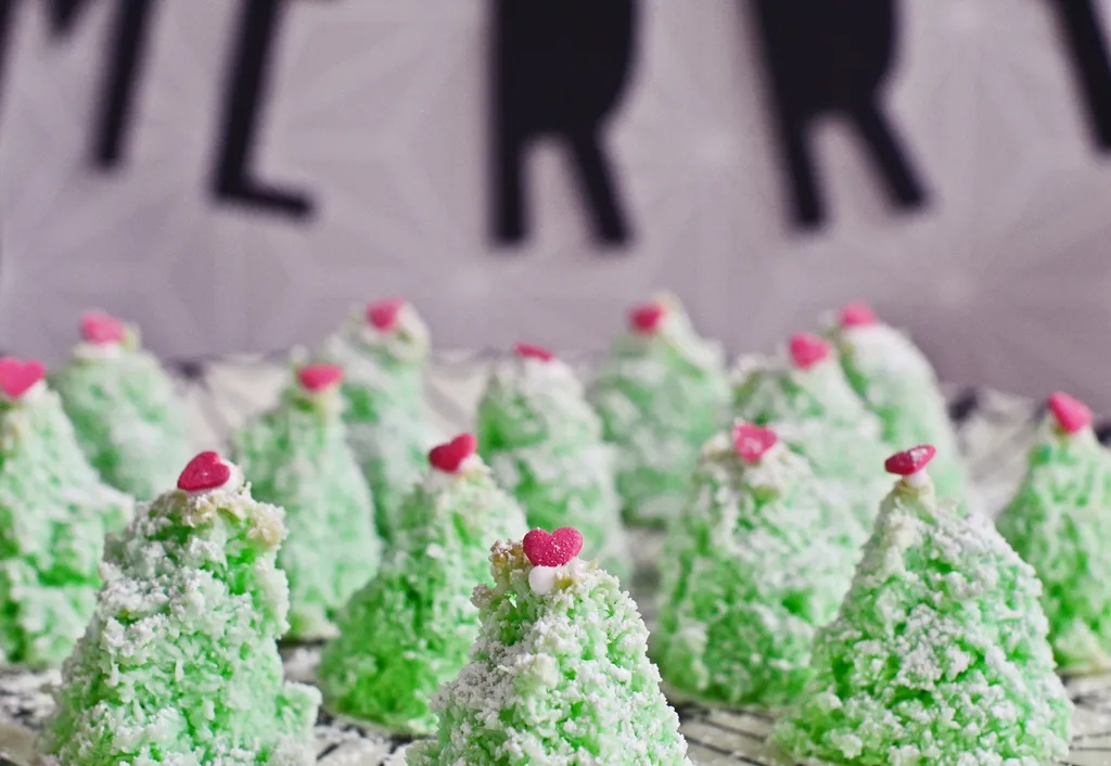 Dekorierte Kokosmakronen-Tannenbäume mit Puderzucker und Zuckerherzchen, eine weihnachtliche Leckerei