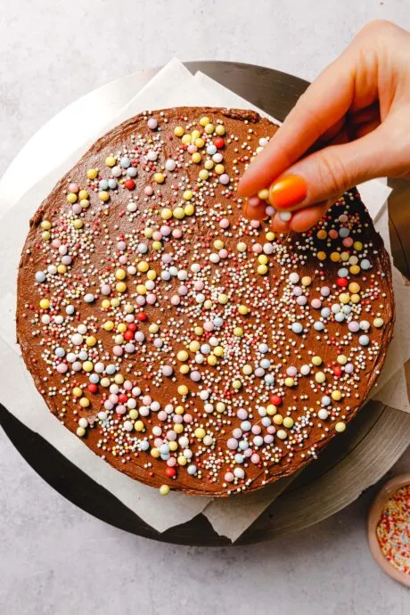 Dekorierter veganer Geburtstagskuchen mit Schoko-Frosting und Streuseln