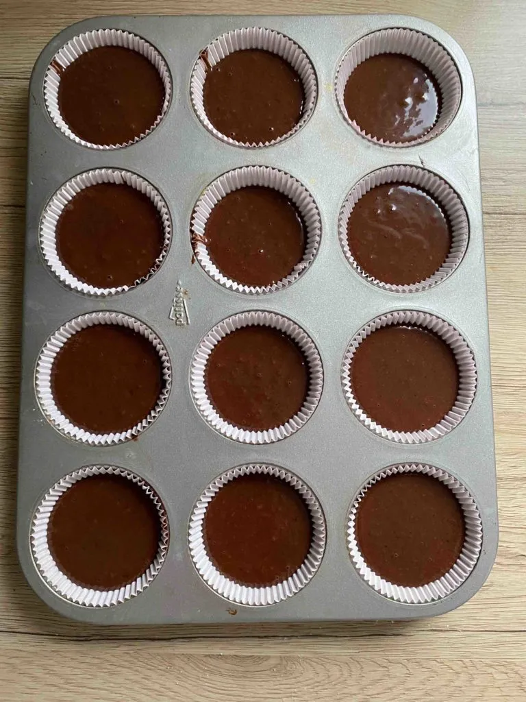 Den zubereiteten Muffinteig in die vorbereiteten Förmchen füllen