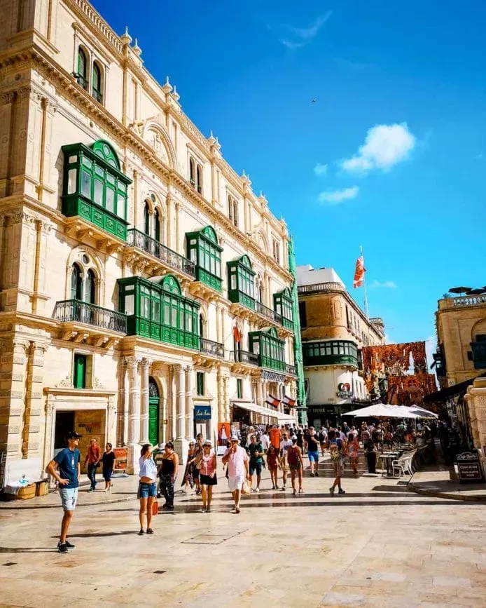 Der belebte Platz beim City Gate in Valletta, Malta, mit historischen Gebäuden und moderner Architektur.