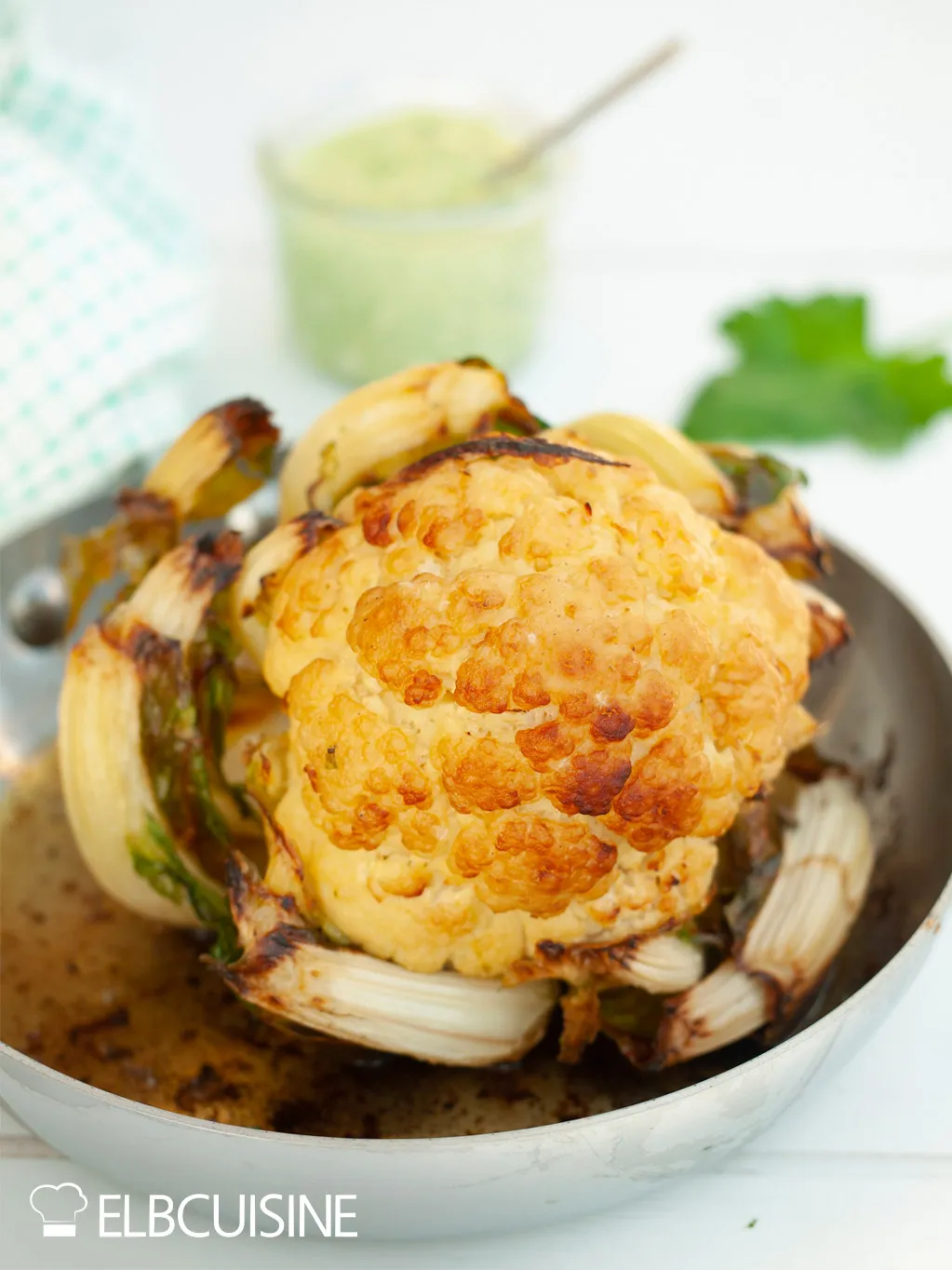 Der Blumenkohl schmort langsam in einer gusseisernen Pfanne, bestrichen mit Butter-Olivenöl-Mischung, Teil der Ottolenghi Rezepte Zubereitung