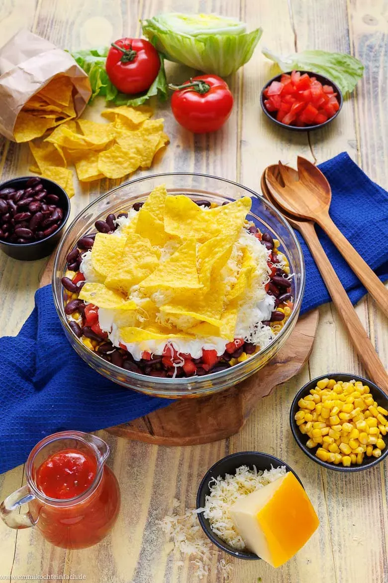 Der fertige mexikanische Schichtsalat mit Hackfleisch, Salsa und frischem Gemüse, perfekt geschichtet und mit knusprigen Tortilla-Chips als Topping.