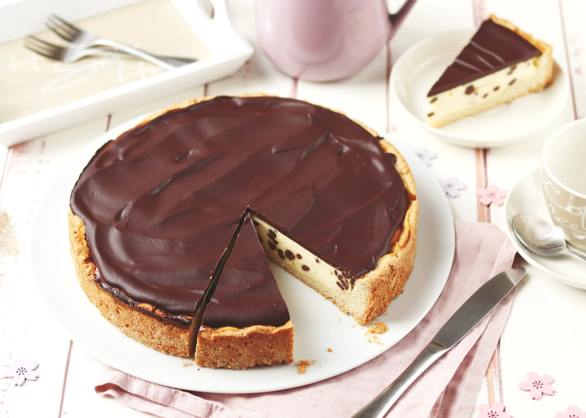 Der frisch gebackene Käsekuchen mit Schokoglasur kühlt auf einem Gitterrost ab, bereit für den Kühlschrank.