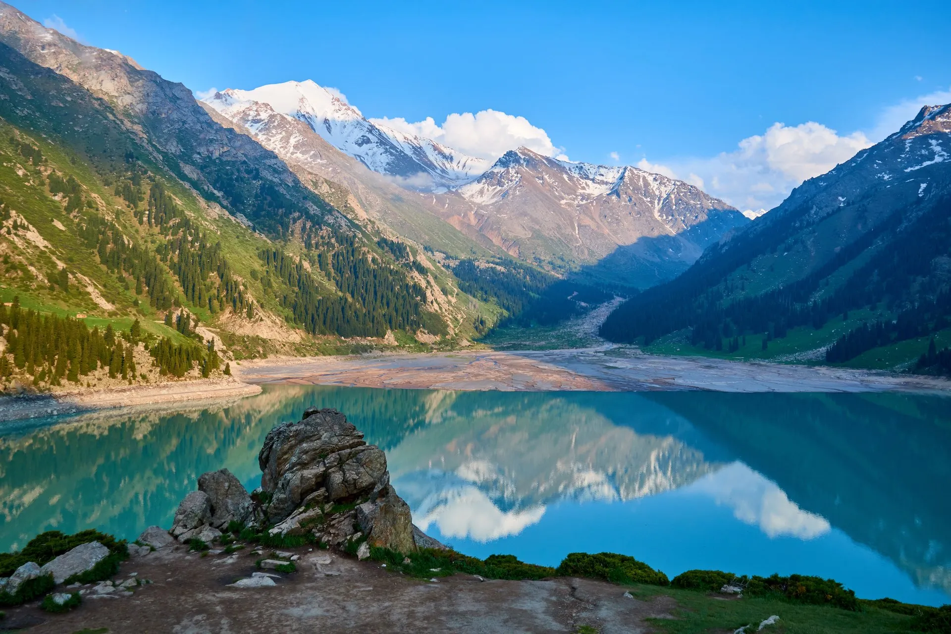 Der Große Almaty-See im Ile-Alatau-Nationalpark, Kasachstan, umgeben von schneebedeckten Bergen