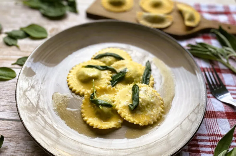 Der Klassiker: Selbstgemachte Ravioli mit Spinat und Ricotta auf einem Teller, mit Salbeiblättern garniert. Eine perfekte Option, um Ravioli selber zu machen.