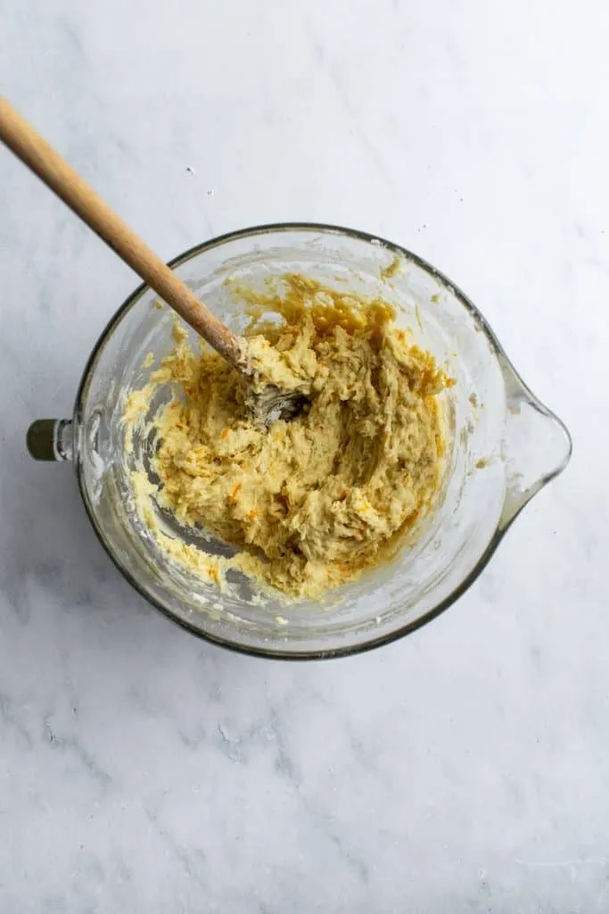 Der klebrige Hefeteig für den Osterkranz in einer großen Glasschüssel, kurz nachdem das Mehl hinzugefügt wurde.