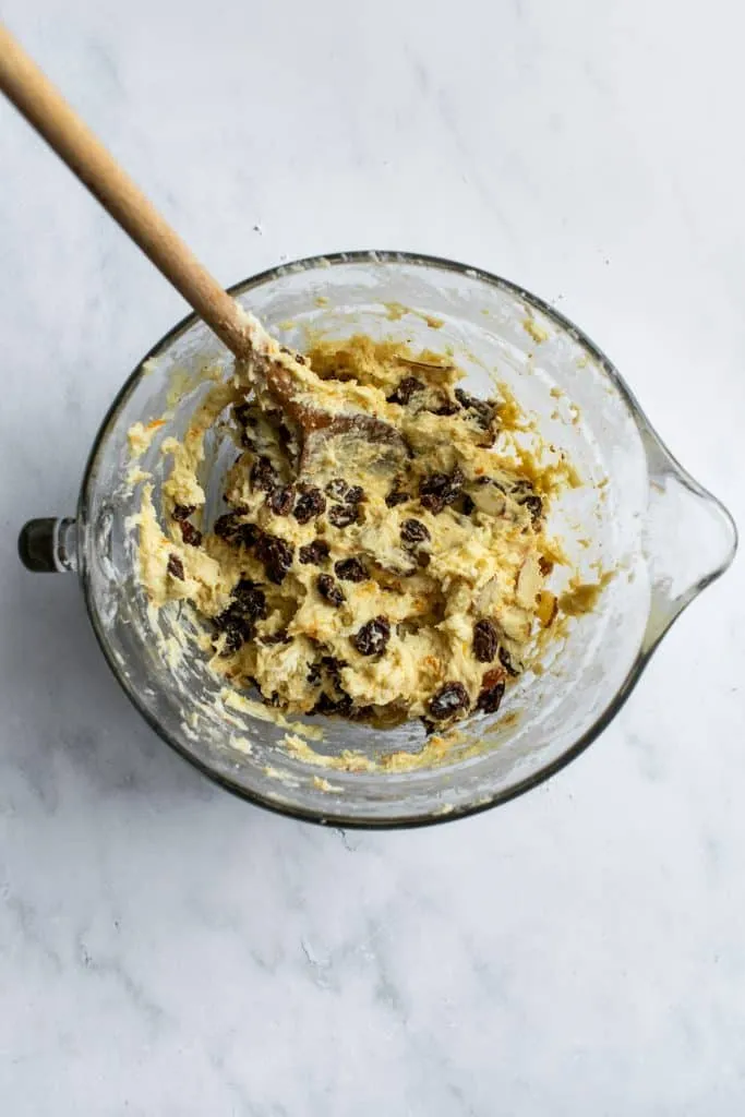 Der klebrige Hefeteig mit eingearbeiteten Rosinen und Mandeln in einer Rührschüssel, bereit zum Kneten.