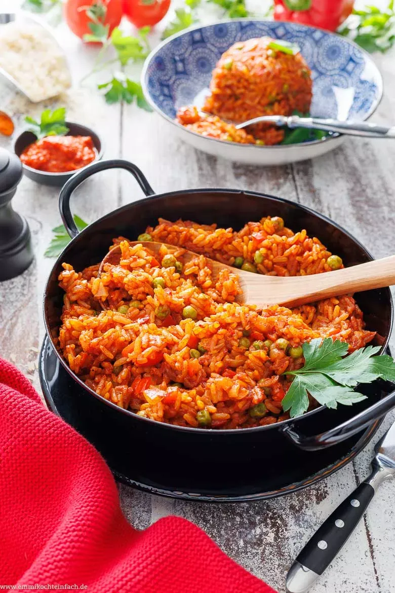 Der köstliche Djuvec Reis köchelt in einer großen schwarzen Pfanne, kurz vor dem Servieren.