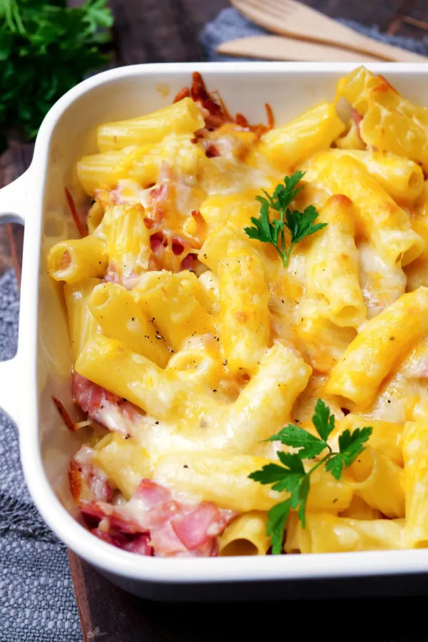 Der köstliche Nudel-Schinken-Gratin in einer rustikalen Auflaufform, knusprig goldbraun überbacken, ein einfaches Gericht ohne Fertigprodukte.