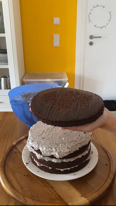 Der letzte Tortenboden wird verkehrt herum aufgesetzt, um eine gerade und glatte Oberfläche zu erzielen.