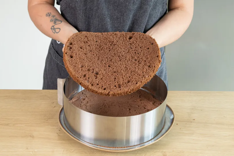 Der mittlere Biskuitboden wird auf die Creme gelegt