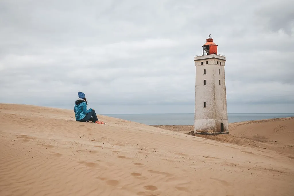 Der Rubjerg Knude Fyr, ein Backsteinturm auf einer Sanddüne, umgeben von einer weiten Landschaft
