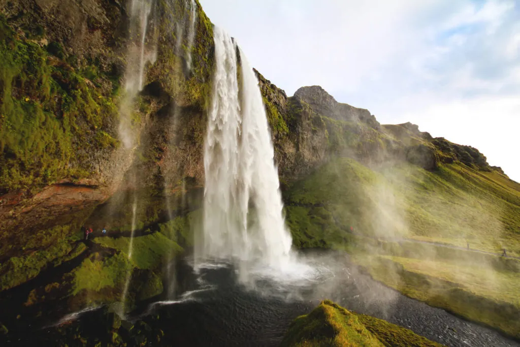 Der Seljalandsfoss Wasserfall in Island, umgeben von grüner Landschaft