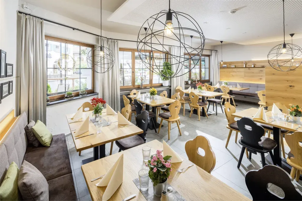 Der stilvolle Frühstücksbereich im Hundesporthotel Wolf in Oberammergau, wo Hunde ihre Besitzer begleiten dürfen und eine entspannte Atmosphäre herrscht.