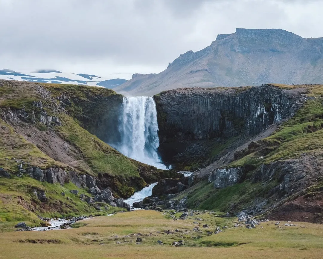 Der Wasserfall Svöðufoss in Island, umgeben von moosbewachsenen Felsen, ein Naturhighlight für Island-Reisende.
