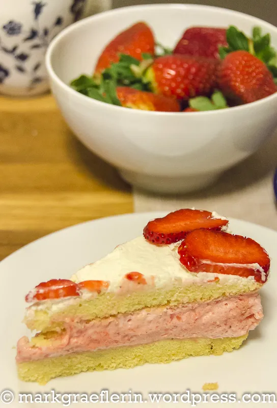 Detailansicht der Erdbeer-Sahnetorte mit frischen, halbierten Erdbeeren und Sahneverzierung